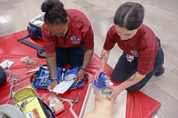 Two EMT - Paramedic students practice emergency medical and lifesaving skills.