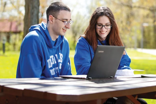 Two students work together at a laptop outside of Main Campus in Canandaigua.
