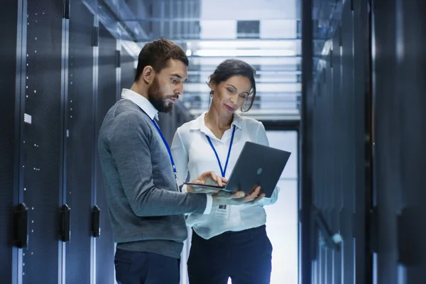 Two computing science professionals looking at a laptop screen.