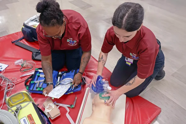 Two EMT - Paramedic students practice emergency medical and lifesaving skills.