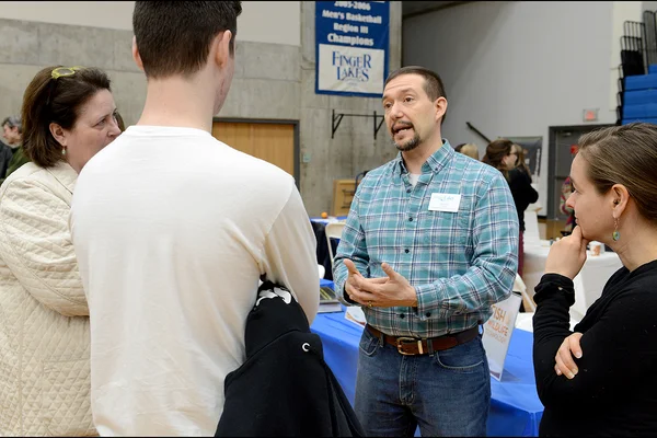 John Foust, standing, talking to three people