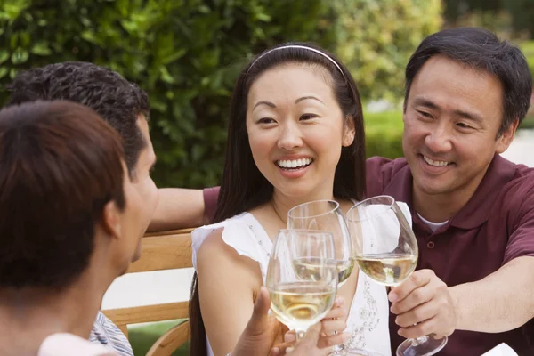 A group of friends gather to enjoy a glass of white wine.