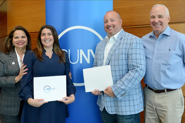 Two women and two men posing at an award event