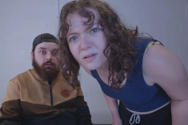 Man and woman peering into camera