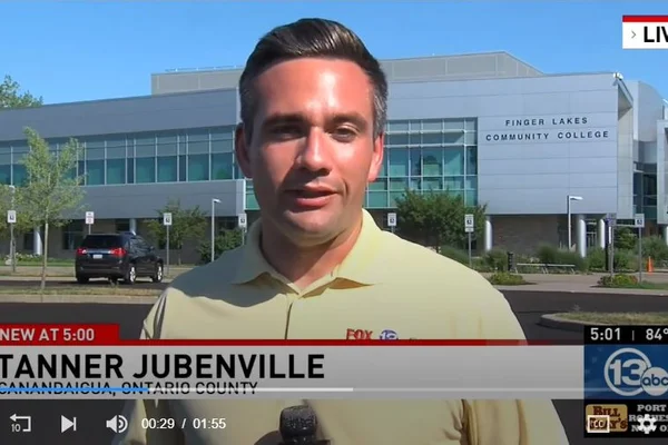 Reporter speaking on camera in front of FLCC main campus