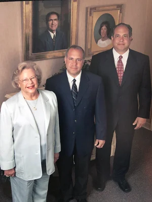 Older woman posing with two grown sons