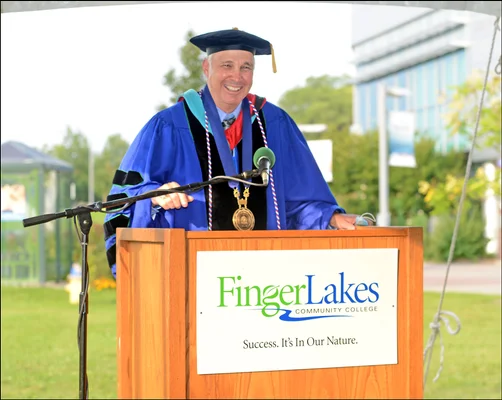 College president in regalia at podium