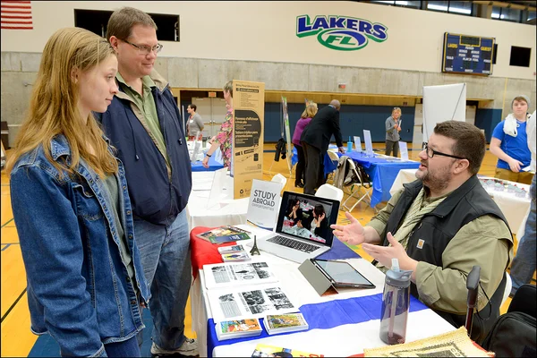 Michael Van Etten, seated, talking to parent, student