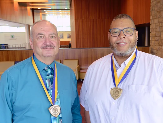 Two men posing, wearing medals