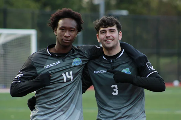 Two FLCC men's soccer players smiling and posing for a photo