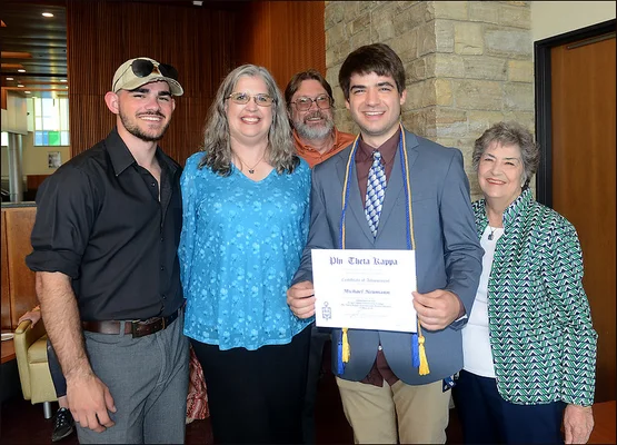 Man holding certificate, posting with family