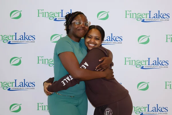 2 young women hugging and looking forward