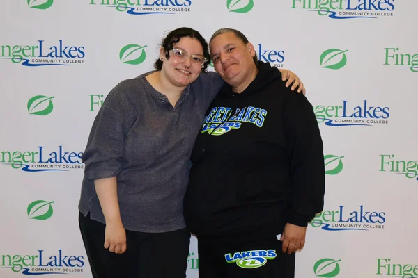 Two women posing and leaning toward one another