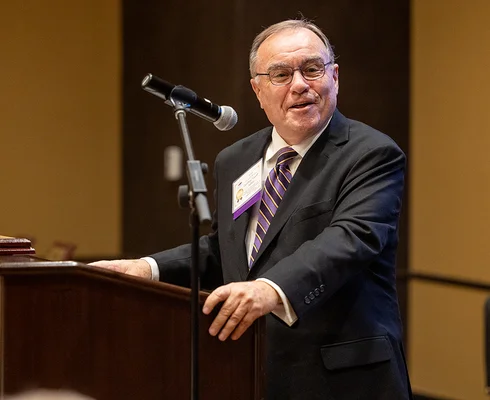 Man smiling at a podium