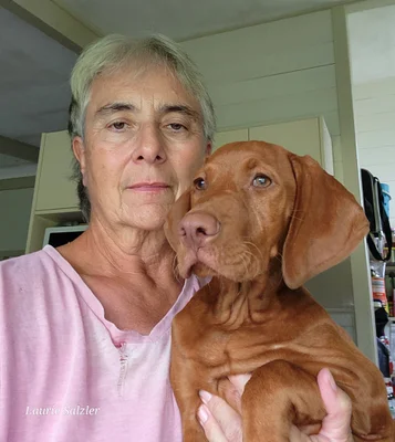 A closeup image of a woman holding a dog