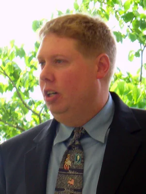 Headshot profile of man in suit