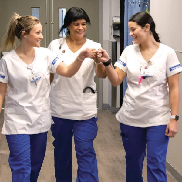 Three nursing students celebrate a job well done at FLCC.